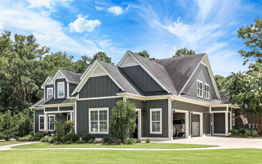 Modern home with grey, fiber siding with a blue sky background.