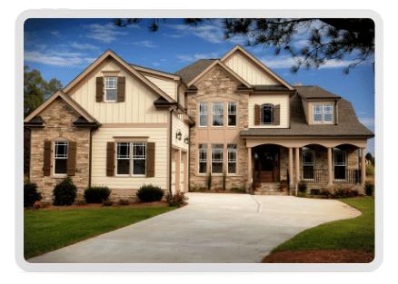 Two-story suburban house with a mix of stone and new siding, large windows, and a front porch. It features a three-car garage and a driveway, surrounded by a manicured lawn under a blue sky.