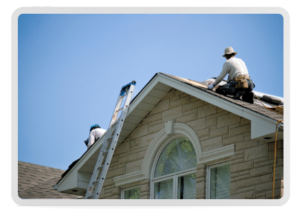 A roofing installer systematically installs an asphalt, engineered roofing shingle from GAF on a beach home finished in cedar wooden siding