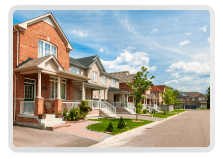 A row of single-family detached homes ordered neatly along a quiet suburban street, showcasing well-kept exteriors and meticulous landscaping.