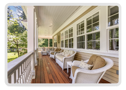 Southern-style, wrap-around porch with luxurious hardwood decking and a modern farmhouse finishing in a a clean & cozy pastel white.