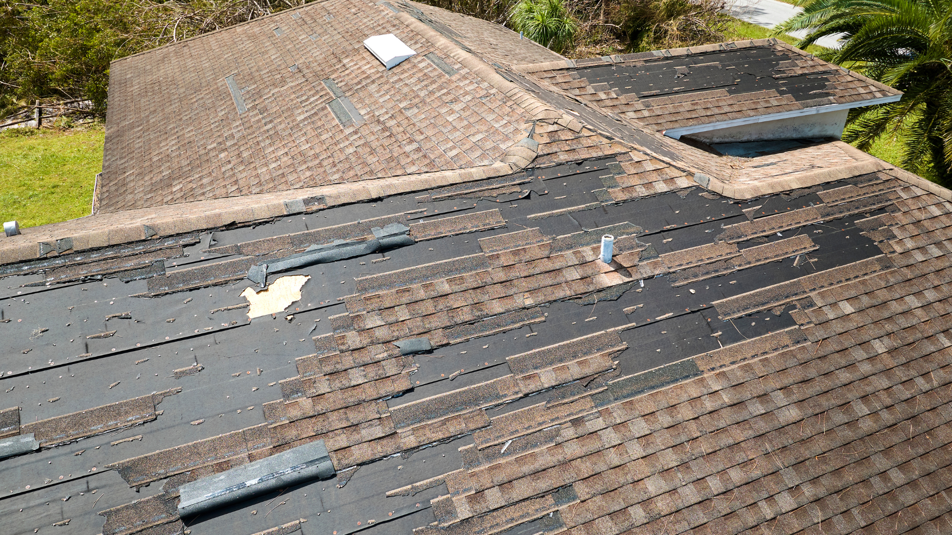 Shingles missing from a badly damaged roof from a wind storm